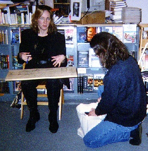 Elizabeth Hand prepping to sign a fan's stack of books.